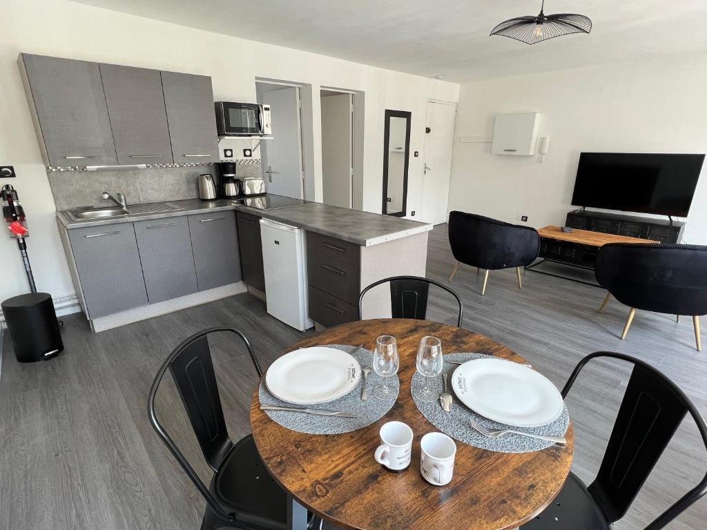 une cuisine et une salle à manger avec une table et des chaises dans l'établissement Les temps modernes, à Boulogne-sur-Mer