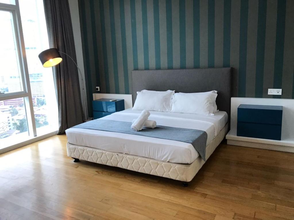 sypialnia z dużym łóżkiem i dużym oknem w obiekcie KLCC Ritz Residence Platinum w Kuala Lumpur