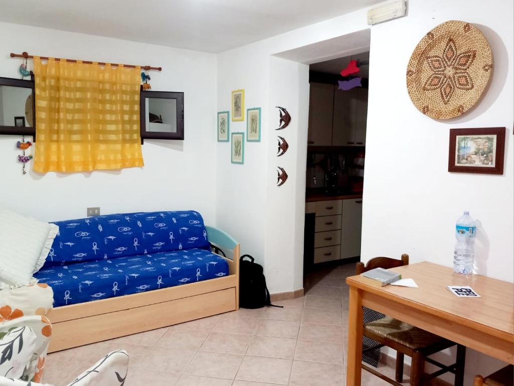sala de estar con sofá azul y mesa en Pinna1 - Appartamento in villetta in pineta - IUN R4823, en S'Archittu
