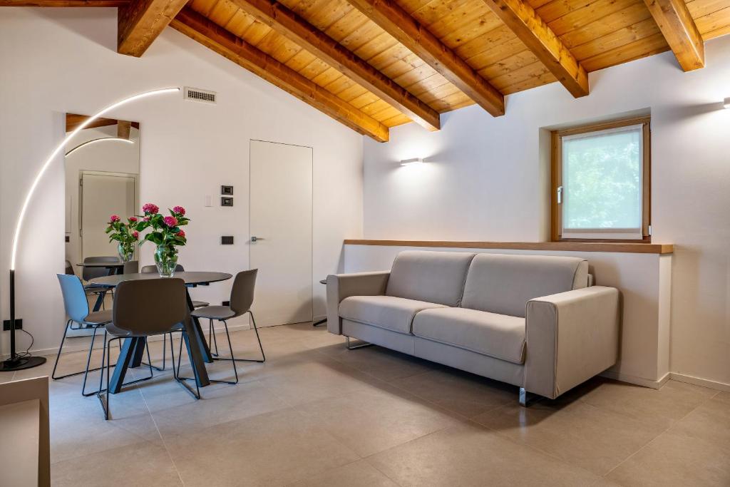een woonkamer met een bank en een tafel bij Appartamento Midum Domus Attic in Trento