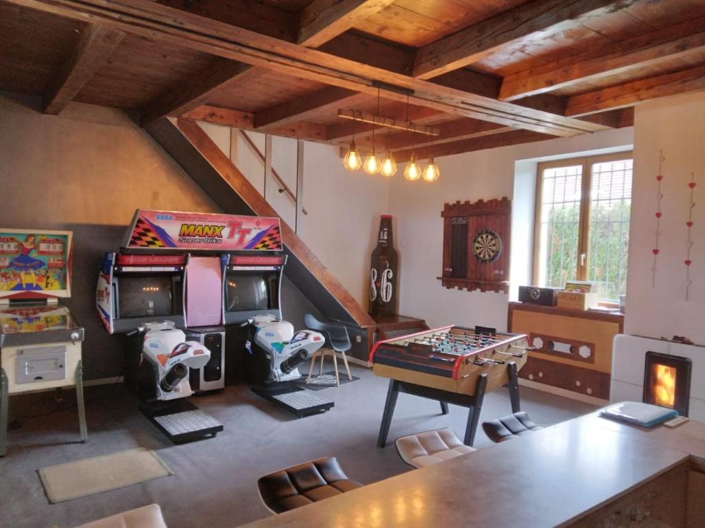 sala de estar con 2 juegos de arcade y mesa en Des Beaux Instants, en Soulosse-sous-Saint-Élophe