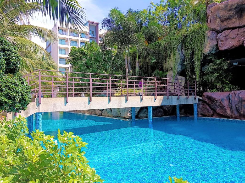 a bridge over a swimming pool with blue water at Laguna Beach Resort 3 Maldives in Jomtien Beach