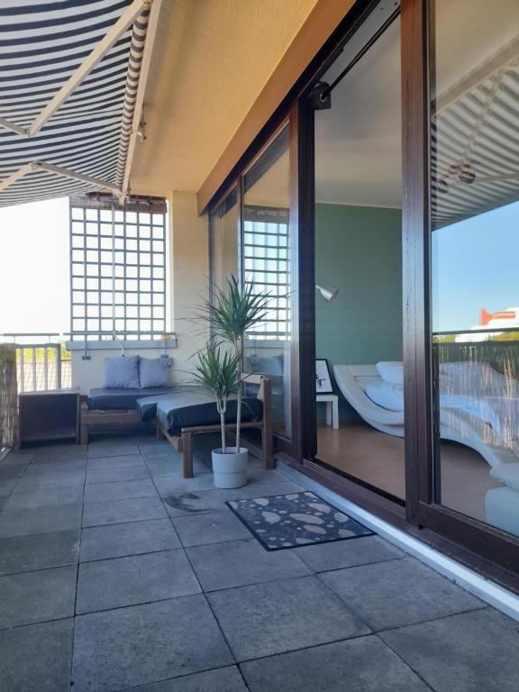 Habitación con patio, sofá y ventanas. en Budget Suite mit Balkon - Privatzimmer in Wohnung - NETFLIX & MINIBAR INKLUSIVE en Coblenza