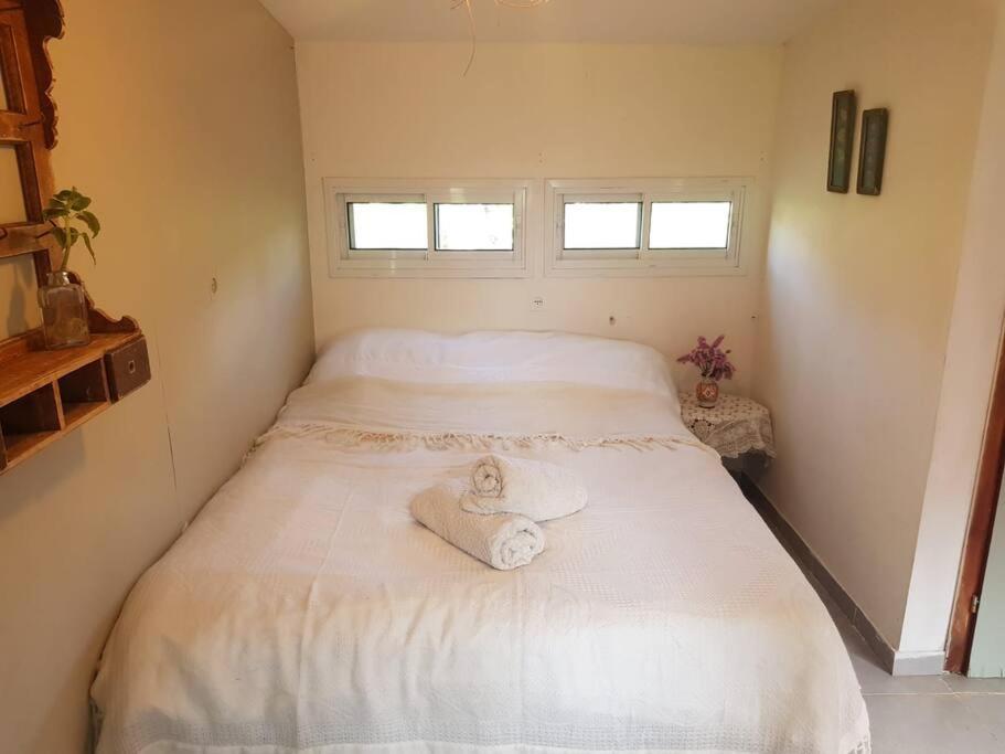 um quarto com uma cama com toalhas em פינה מתוקה בעמק החולה em Yesud HaMa‘ala