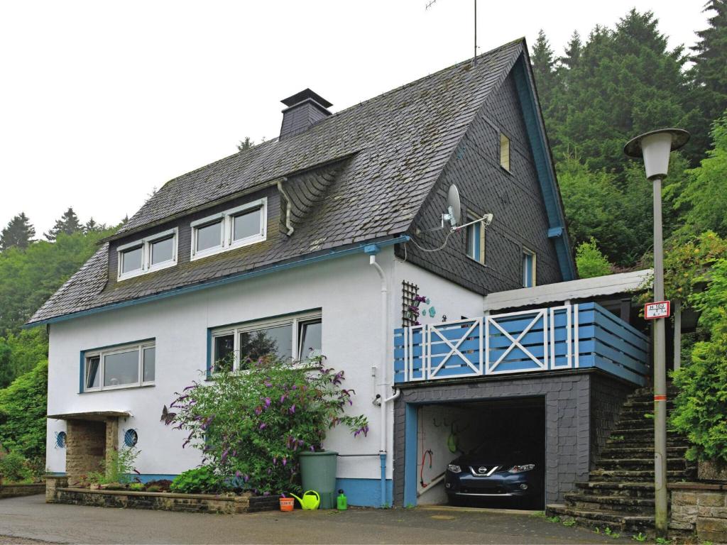 a house with a garage with a car in it at Spacious apartment in Rattlar with private terrace in Willingen
