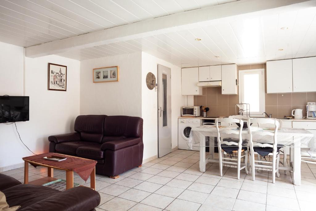 un salon avec un canapé et une table et une cuisine dans l'établissement Appartement à 5mn de la plage, à Six-Fours-les-Plages