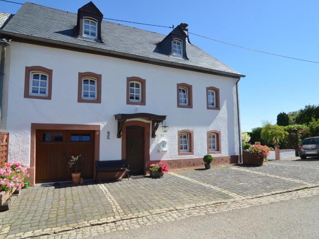 a large white house with a garage at Appealing Apartment in Ittel with Garden Parking Bicycles in Welschbillig