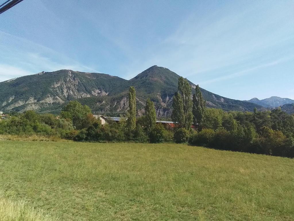 a field with trees and mountains in the background at MAISON DE VILLAGE ST MARCELLIN in Veynes