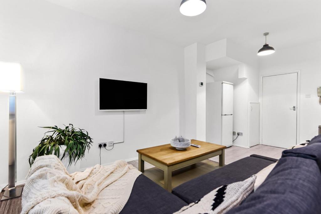 a living room with a couch and a table at Finsbury Park Station Apartment! (B) in London