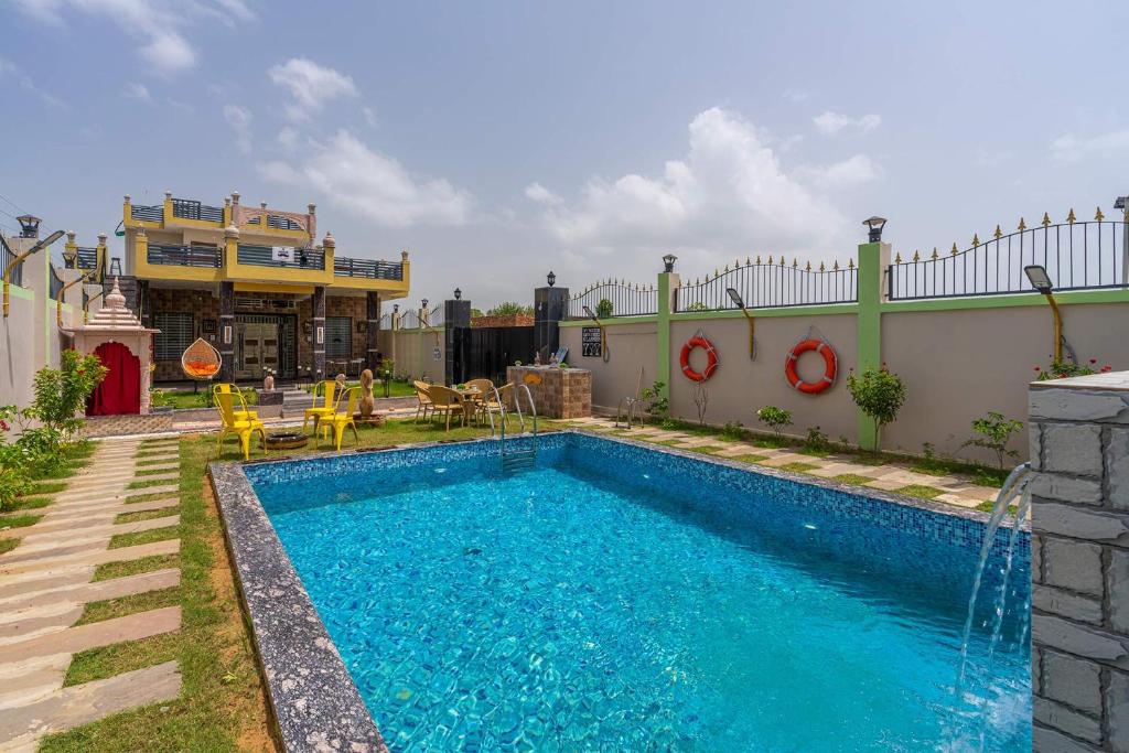 uma piscina no quintal de uma casa em StayVista's Badshah Farmstay - Mountain-View Villa with Private Pool, Terrace & Gym em Shāhpura