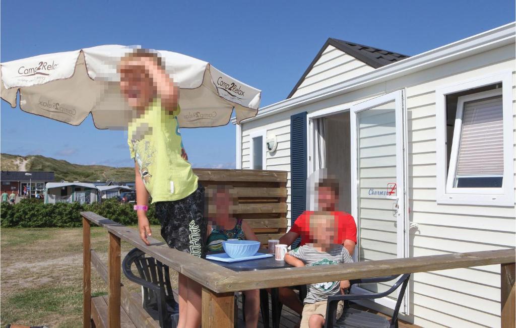 ヴィデ・サンデにあるGorgeous Home In Hvide Sande With Indoor Swimming Poolの二人がデッキのテーブルに座っている