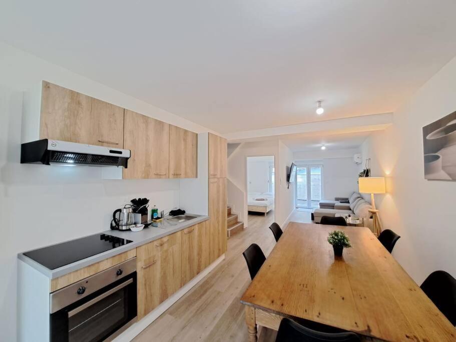 - une cuisine et une salle à manger avec une table en bois dans l'établissement Mascate - Appartement Climatisé en Hypercentre, à Reims