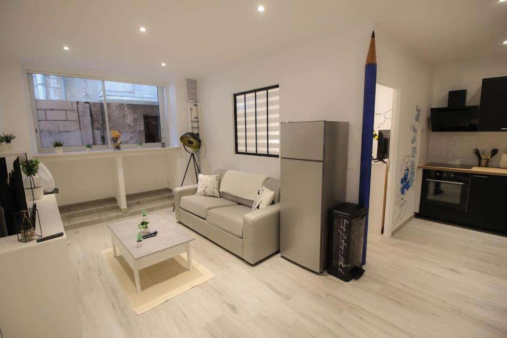 - un salon avec un canapé et un réfrigérateur dans l'établissement la BD : joli T2 rénové /Wi-fi/centre-ville, à Angoulême