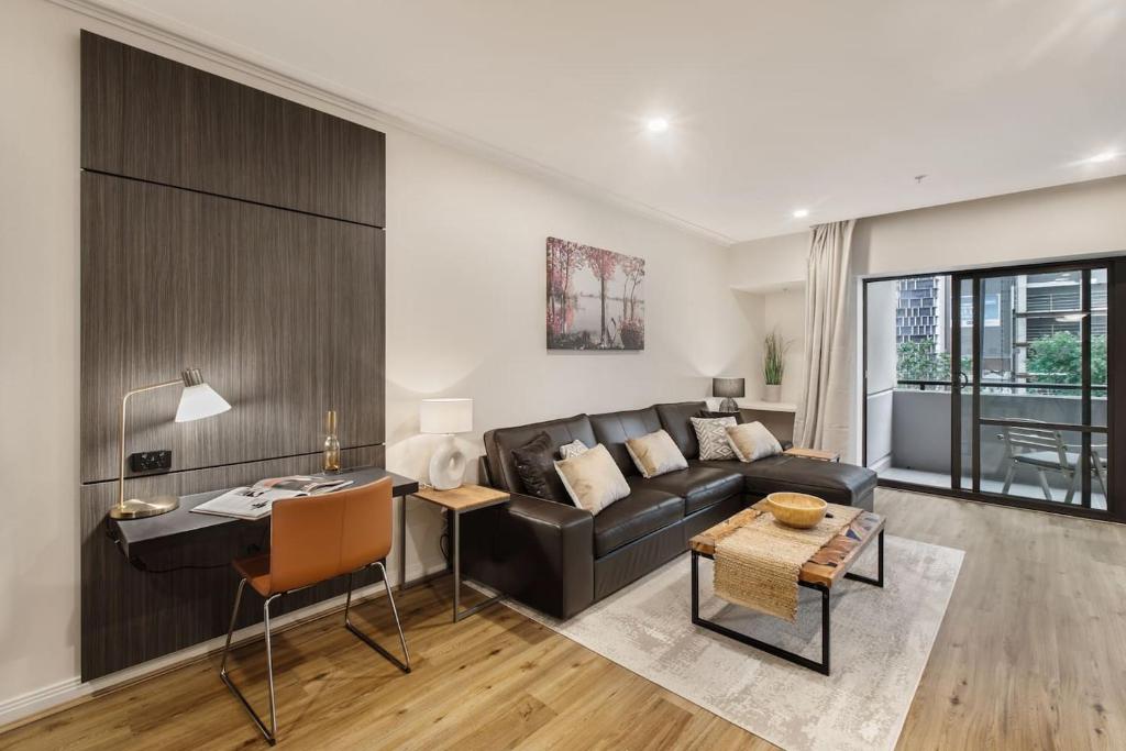 a living room with a couch and a table at Spacious Inner-city Stay with King Bed and Balcony in Melbourne