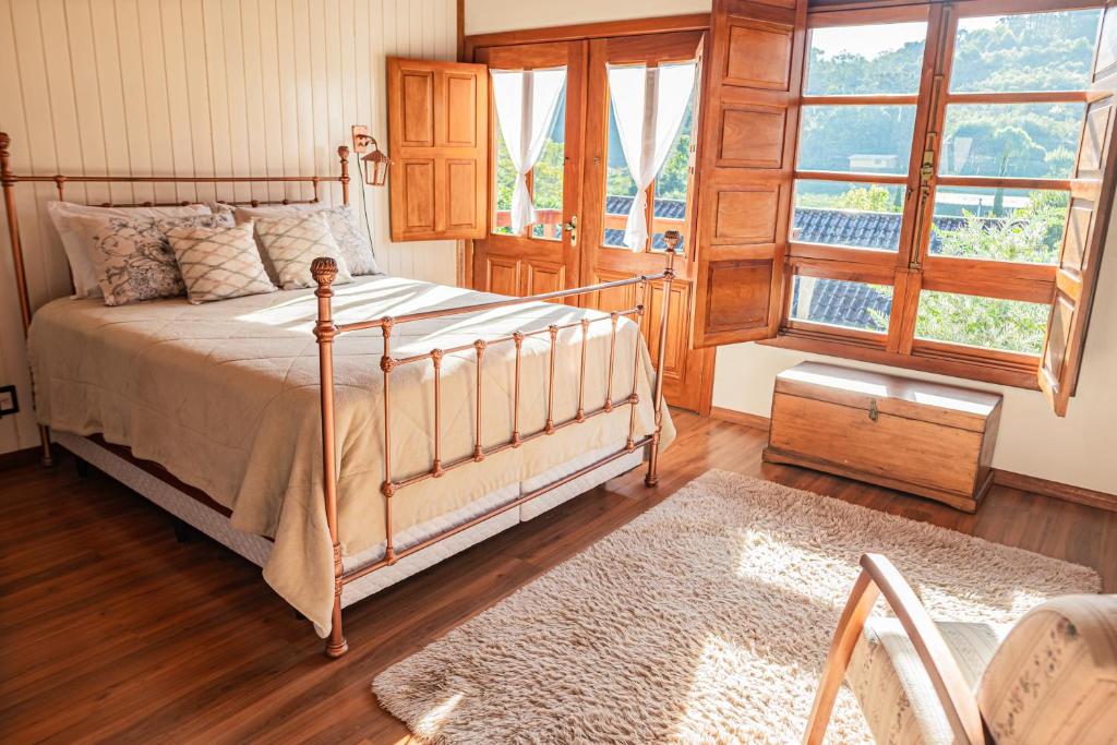 sypialnia z łóżkiem i dużym oknem w obiekcie Casarão do Vale dos Vinhedos w mieście Bento Gonçalves