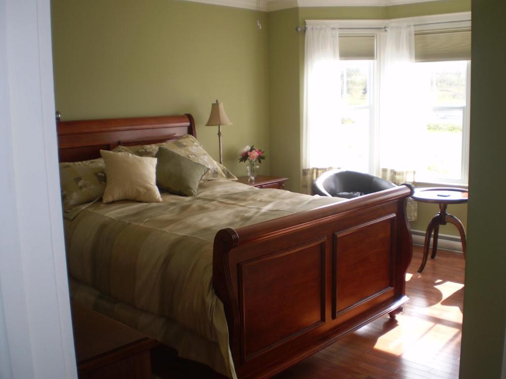 - une chambre avec un grand lit et une fenêtre dans l'établissement Lancaster Inn B&B, à Bonavista