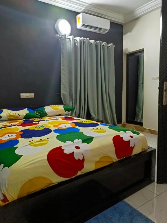 una camera da letto con un letto con un piumone colorato di Reserva africa 3D a Lomé