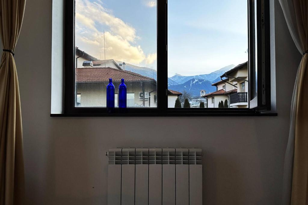 two blue bottles are sitting in a window at 2br Mountain View Apartment - 250mbps Wifi in Bansko