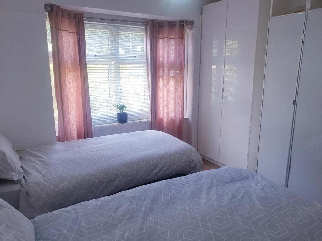 a bedroom with two beds and a window at double room in Thornton Heath