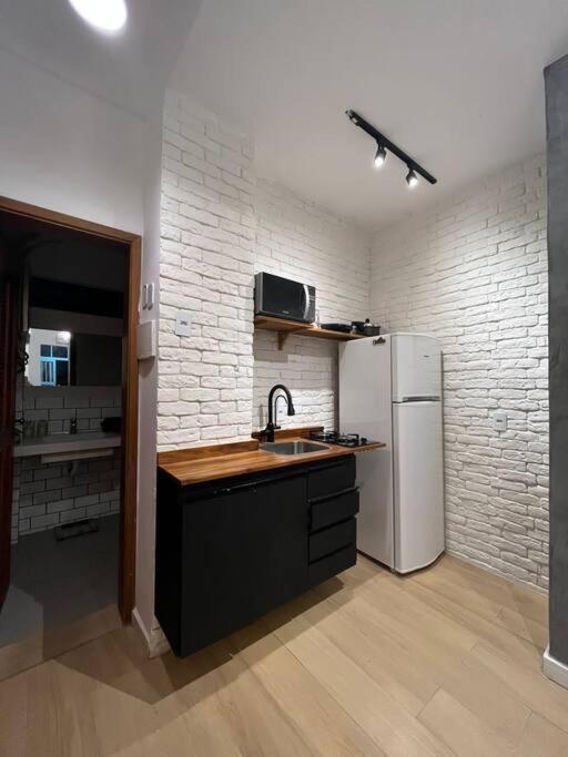 uma cozinha com um lavatório e um frigorífico branco em Subsolo 101 no Rio de Janeiro