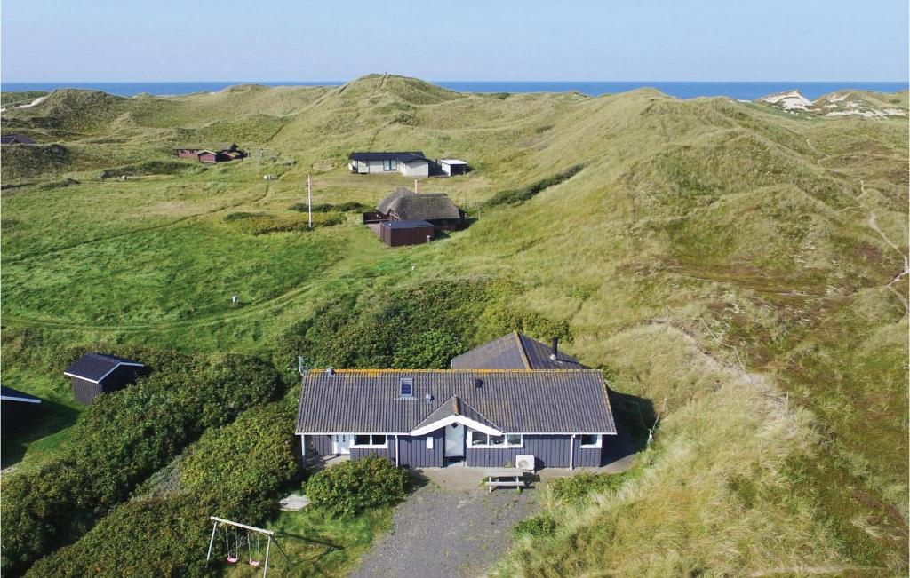 HalkærにあるBeautiful Home In Ringkbing With Wifiの海を背景にした丘の上の家