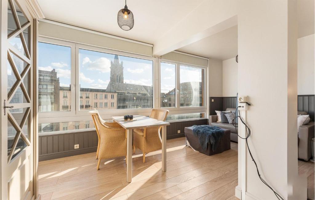 Zimmer mit einem Tisch und Stühlen sowie einem großen Fenster in der Unterkunft Nice Apartment In Blankenberge With Wifi in Blankenberge