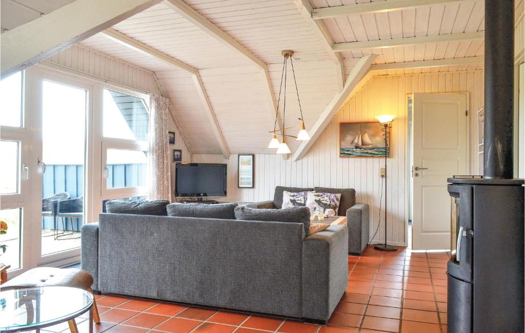 ein Wohnzimmer mit einem Sofa und einem TV in der Unterkunft 2 Bedroom Awesome Home In Hvide Sande in Havrvig