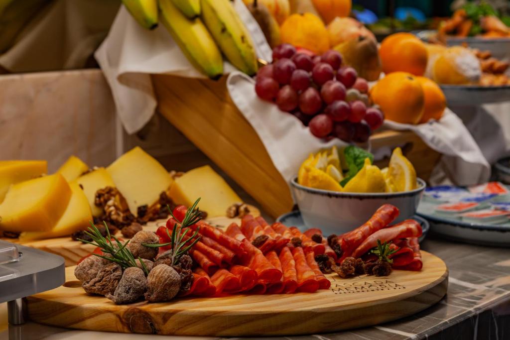 A buffet display of fruit, cheese, cured meats and other breakfast items.