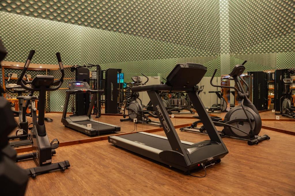A compact fitness room equipped with treadmills, bikes and other cardio machines.