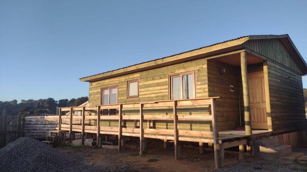 een houten huis met een veranda op een berg puin bij Cabaña pullay in Cobquecura