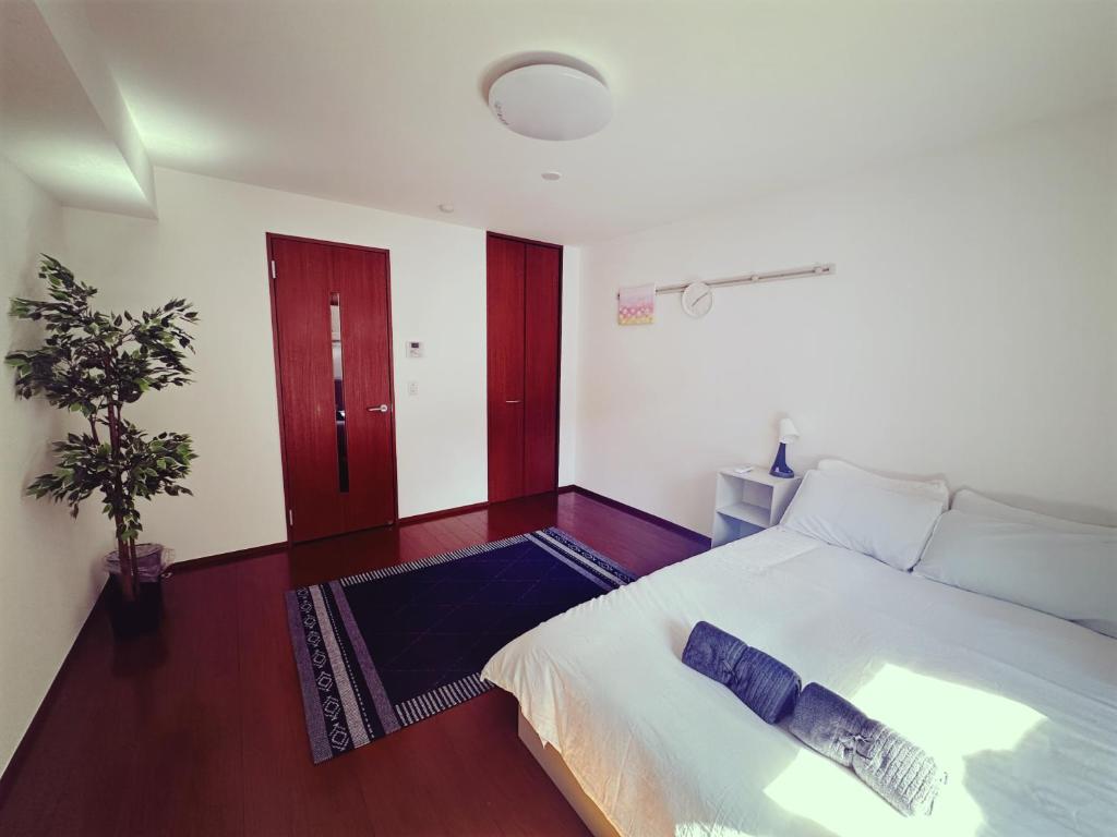 a bedroom with a large bed with blue pillows on it at Brand New Shinjuku Station 5 Mins - Apartment D in Tokyo