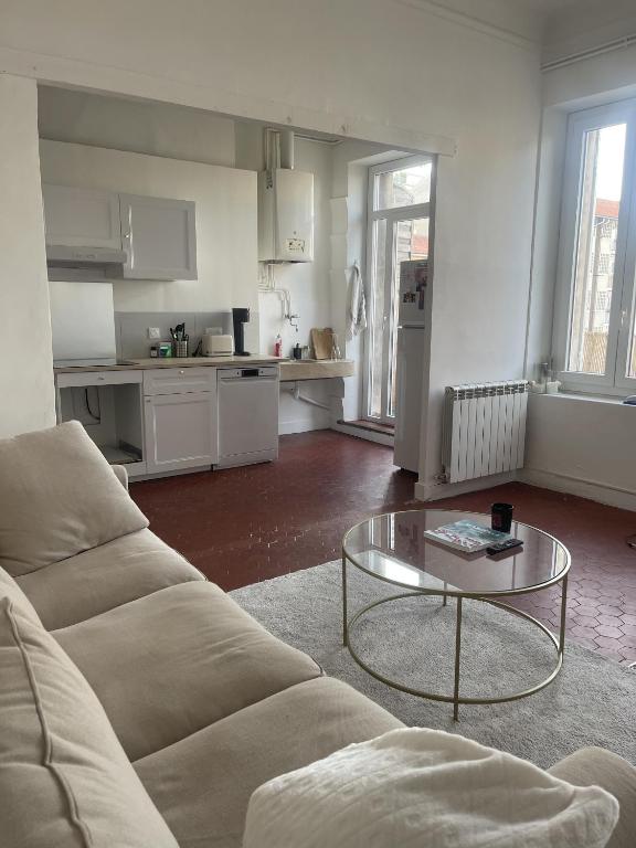 un salon avec un canapé et une table en verre dans l'établissement Appartement Marseille 13008 - 5min à pied Stade Vélodrome, à Marseille