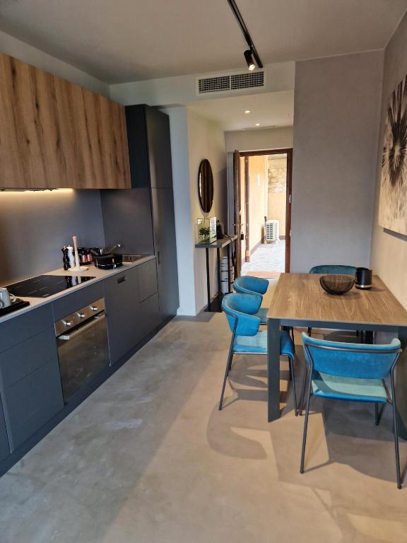 a kitchen with a wooden table and blue chairs at Appartamento Vista Forra in Tremosine Sul Garda