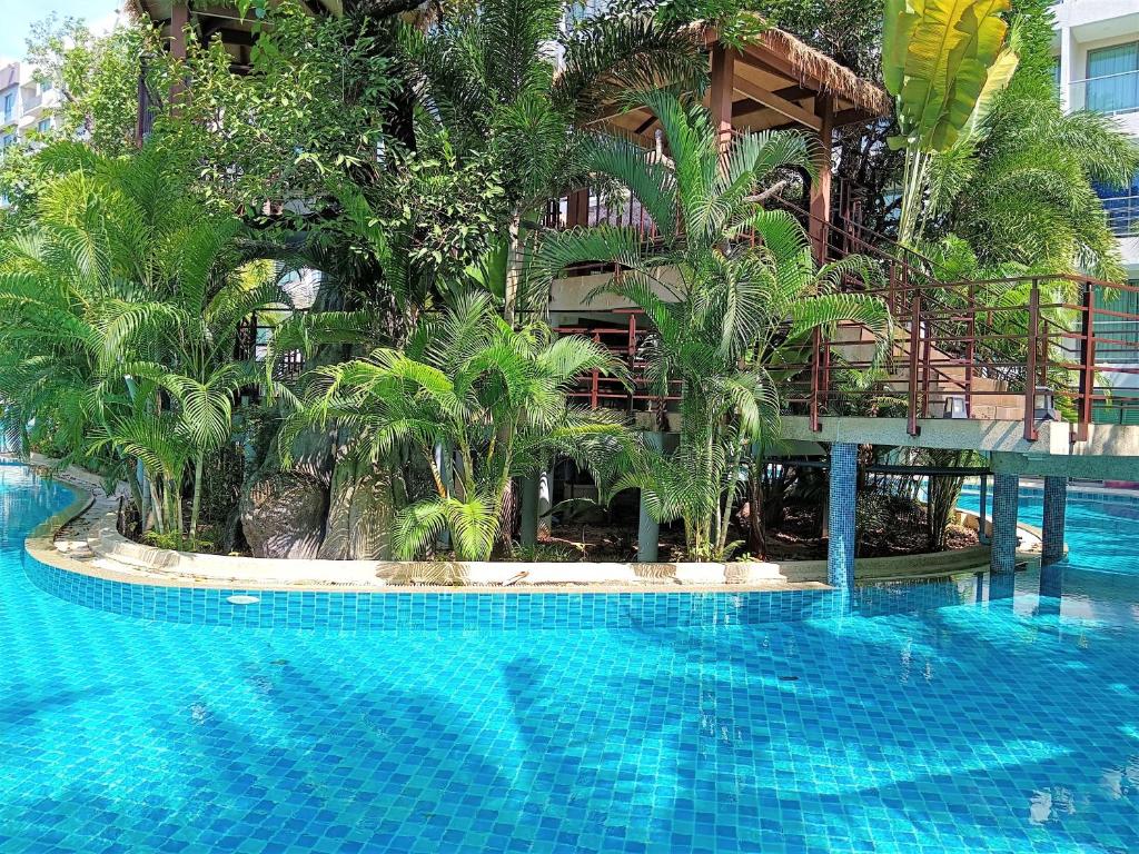 a resort with a large swimming pool with palm trees at Laguna Beach Resort 3 Maldives in Jomtien Beach