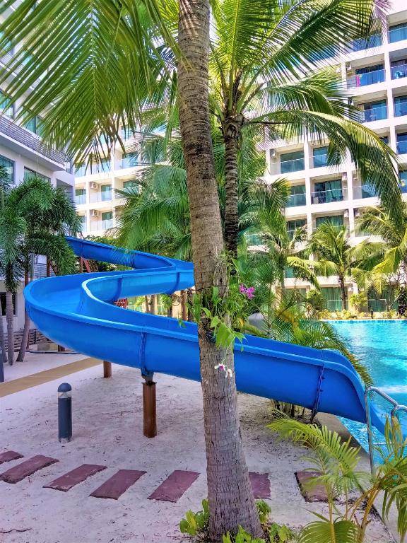 a blue slide in front of a palm tree at Laguna Beach Resort 3 Maldives in Jomtien Beach