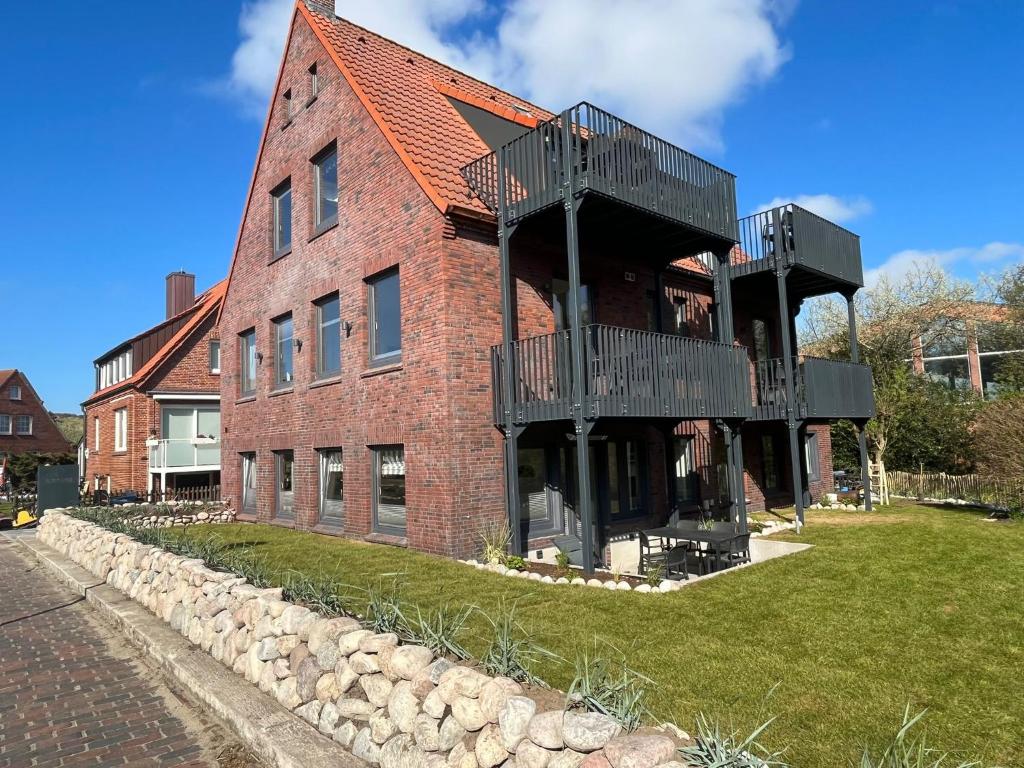 a brick building with balconies on the side of it at Dünen Lodge 3 in Juist
