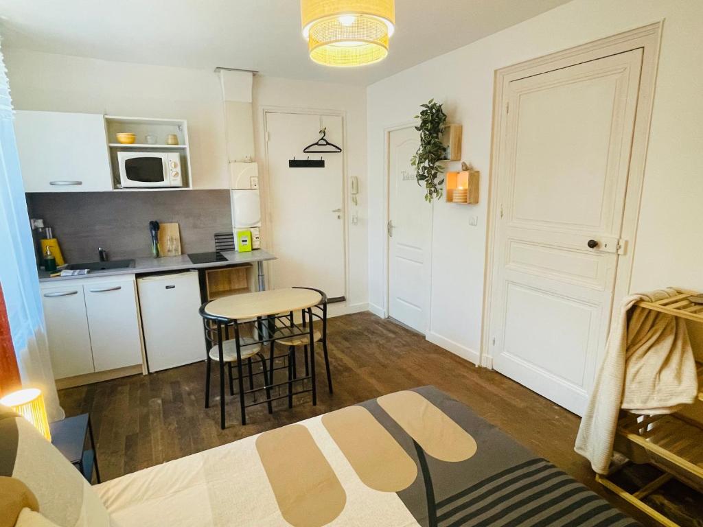 eine Küche mit einem Tisch und Stühlen im Zimmer in der Unterkunft Le Romélia - Wifi Fibre - Calme - Parking in Angoulême