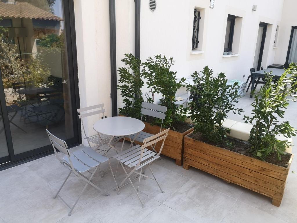 un patio con mesa, sillas y plantas en Chez Mélanie, en Marsella