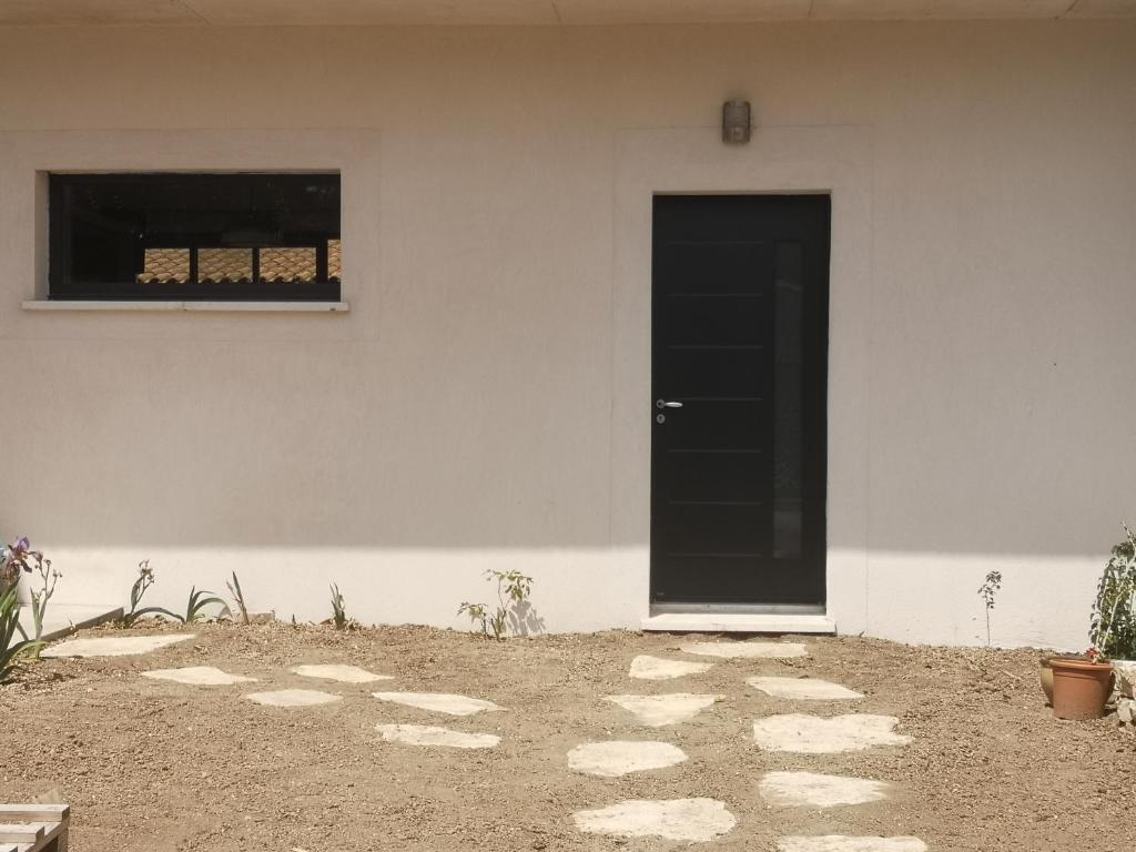 a white building with a black door and a window at Chez Mélanie in Marseille