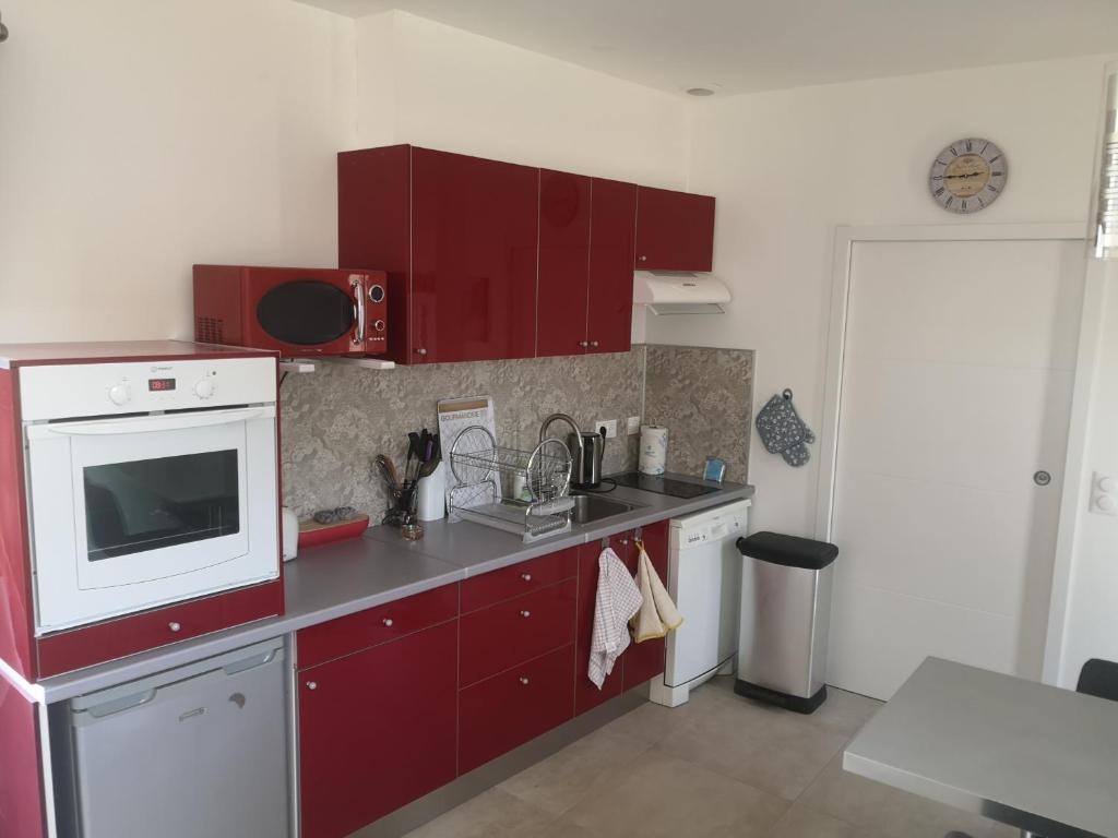 a kitchen with red cabinets and a microwave at Chez Mélanie in Marseille