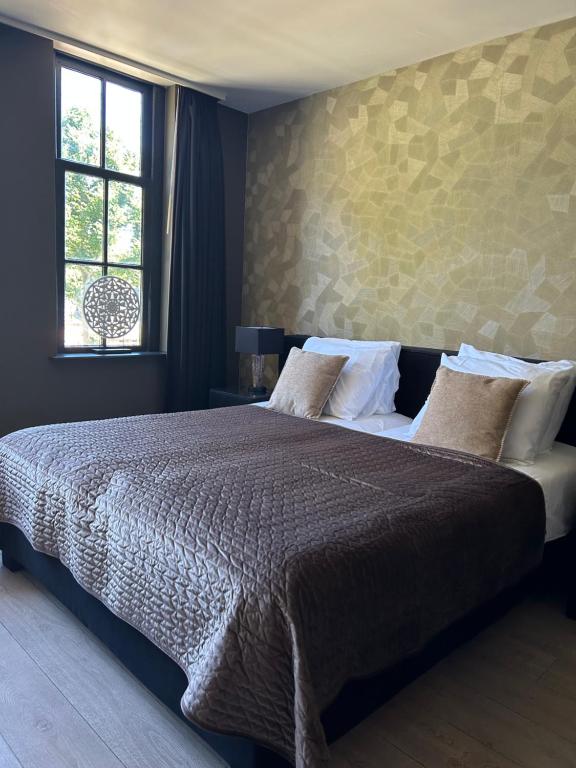 a bedroom with a large bed and a window at Het Wapen van Rhoon in Rhoon
