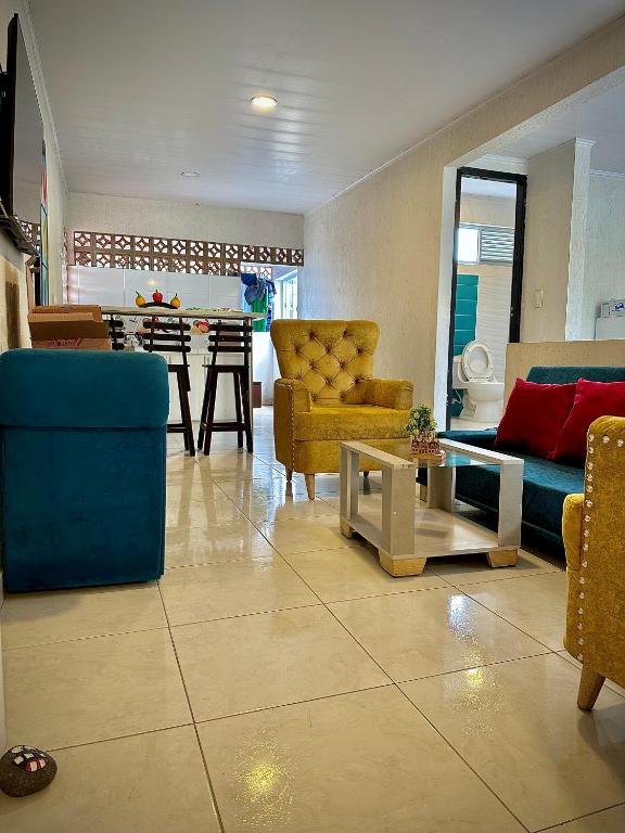 ein Wohnzimmer mit gelben und blauen Stühlen und einem Tisch in der Unterkunft Apartamento sector aeropuerto in Manizales
