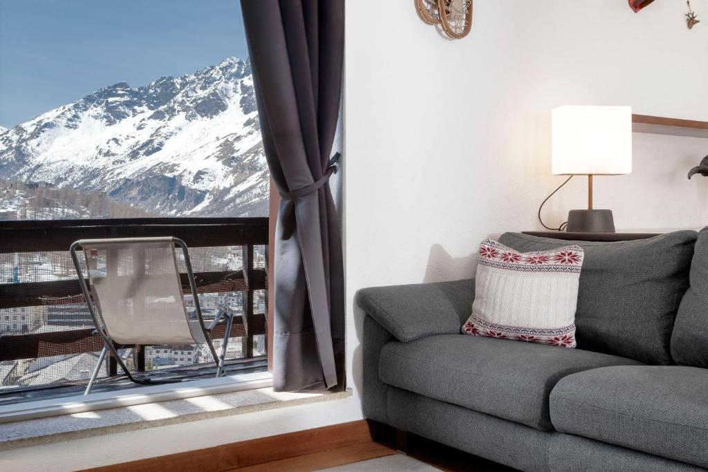 ein Wohnzimmer mit einem Sofa und Bergblick in der Unterkunft HelloChalet - Ski paradise Apartment - Ski- to door with big terrace overlooking skiruns in Breuil-Cervinia