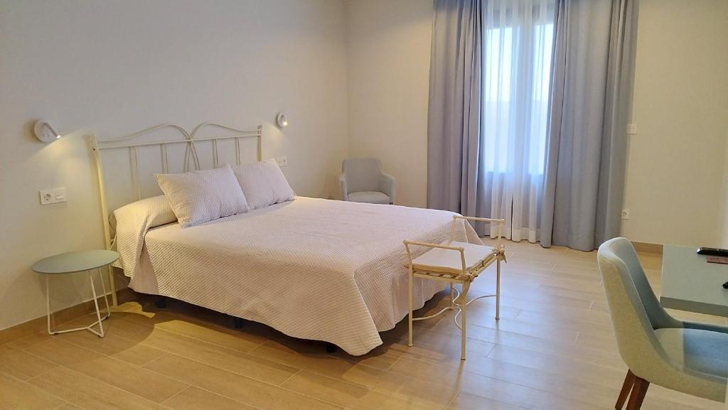 1 dormitorio con 1 cama, mesa y sillas en Hotel Vinoteca Alquezar - Adults Only -, en Alquézar