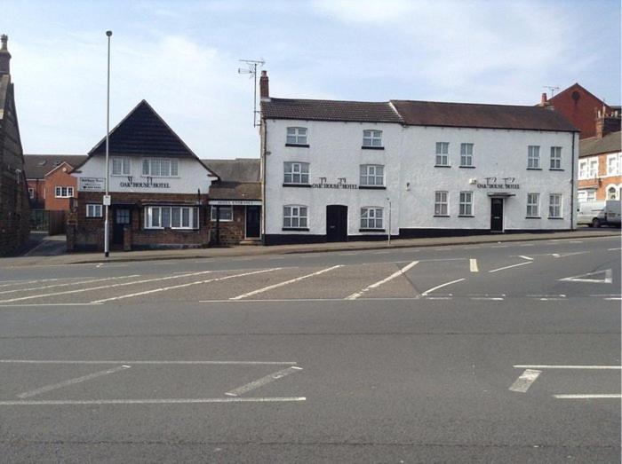 an empty street in front of a white building at Oak house hotel in Wellingborough
