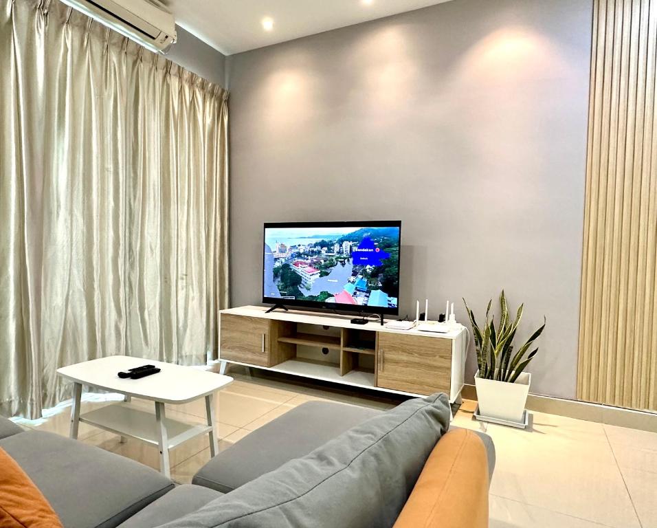 a living room with a couch and a flat screen tv at IJM Condo with Pool #Yoyo Homestay in Sandakan