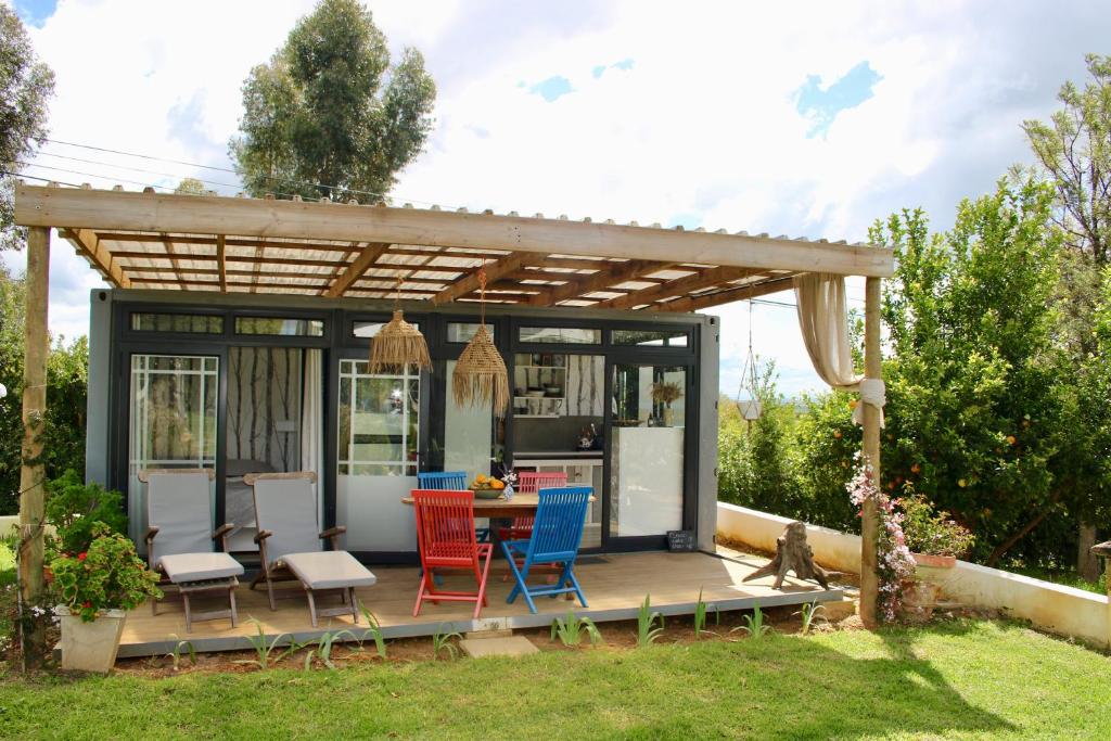 eine Pergola mit einem Tisch und Stühlen auf einer Terrasse in der Unterkunft The tiny home in Riebeek-Wes