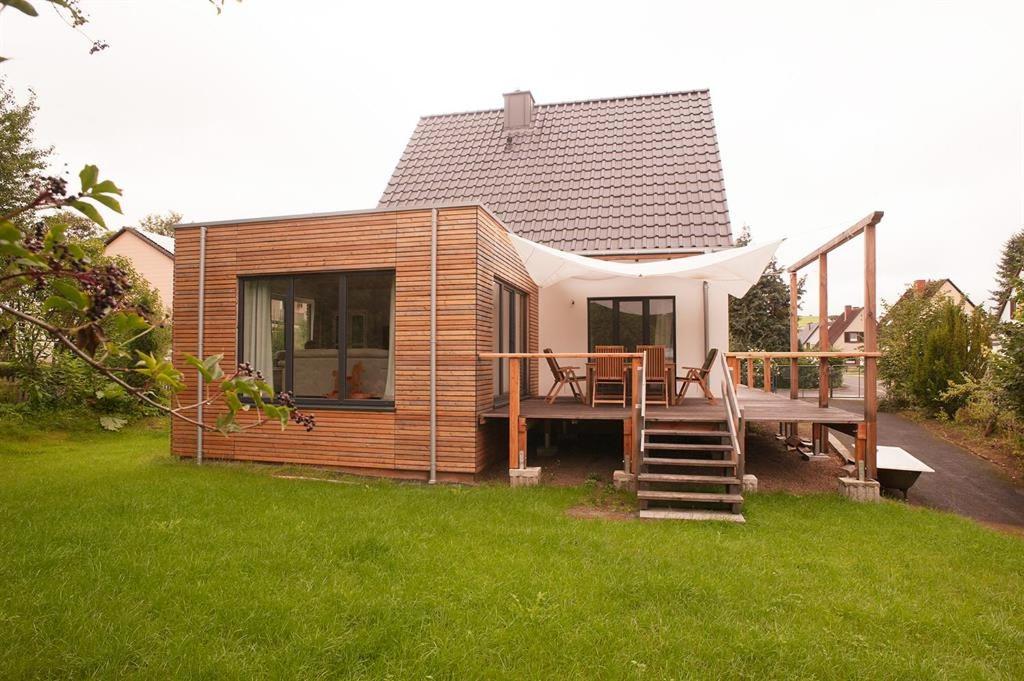 a small house with a deck in the grass at Ferienhaus Hillesheim in Hillesheim