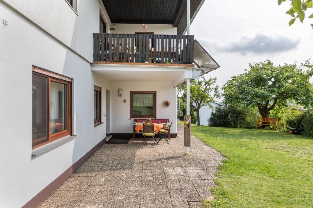 a house with a balcony and a yard at Ferienwohnung Haus-schirmer in Bad Wildungen
