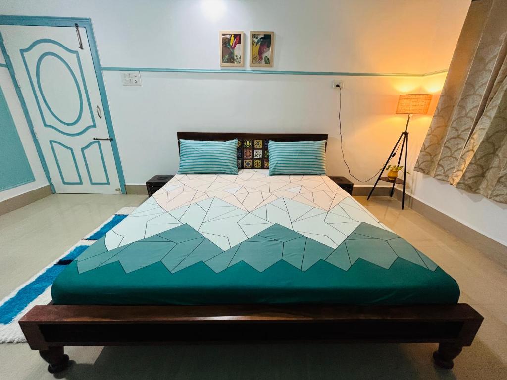 ein Schlafzimmer mit einem Kingsize-Bett mit einer geometrischen Tagesdecke in der Unterkunft *URBAN HOME*-A Luxe Contemporary 1BHK Apartment in Guwahati